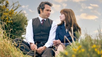 Tom Cullen and Lola Petticrew sat on grass staring lovingly at each other in the Channel 4 drama Trespasses