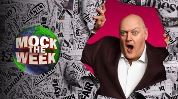 romotional image for Mock the Week featuring a person tearing through a collage of black-and-white newspaper headlines, revealing a bright pink background behind them. On the left side, the show’s logo displays the words ‘Mock the Week’ in bold red and white letters over a green and blue globe.