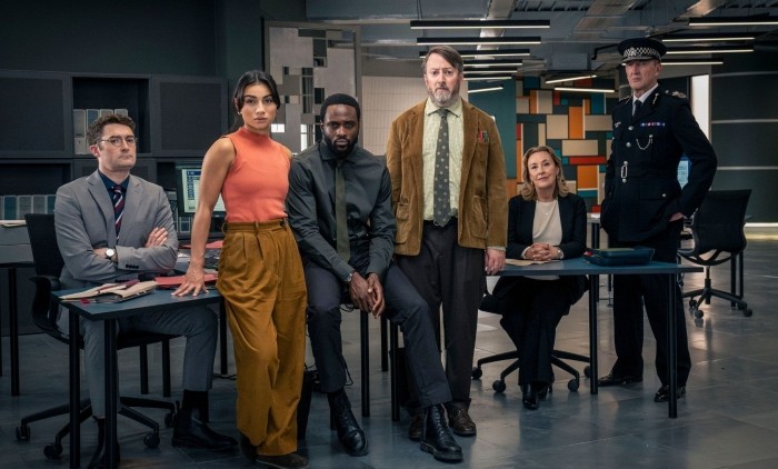 Promotional image for Ludwig featuring the investigative team inside a modern police headquarters during a complex criminal investigation.