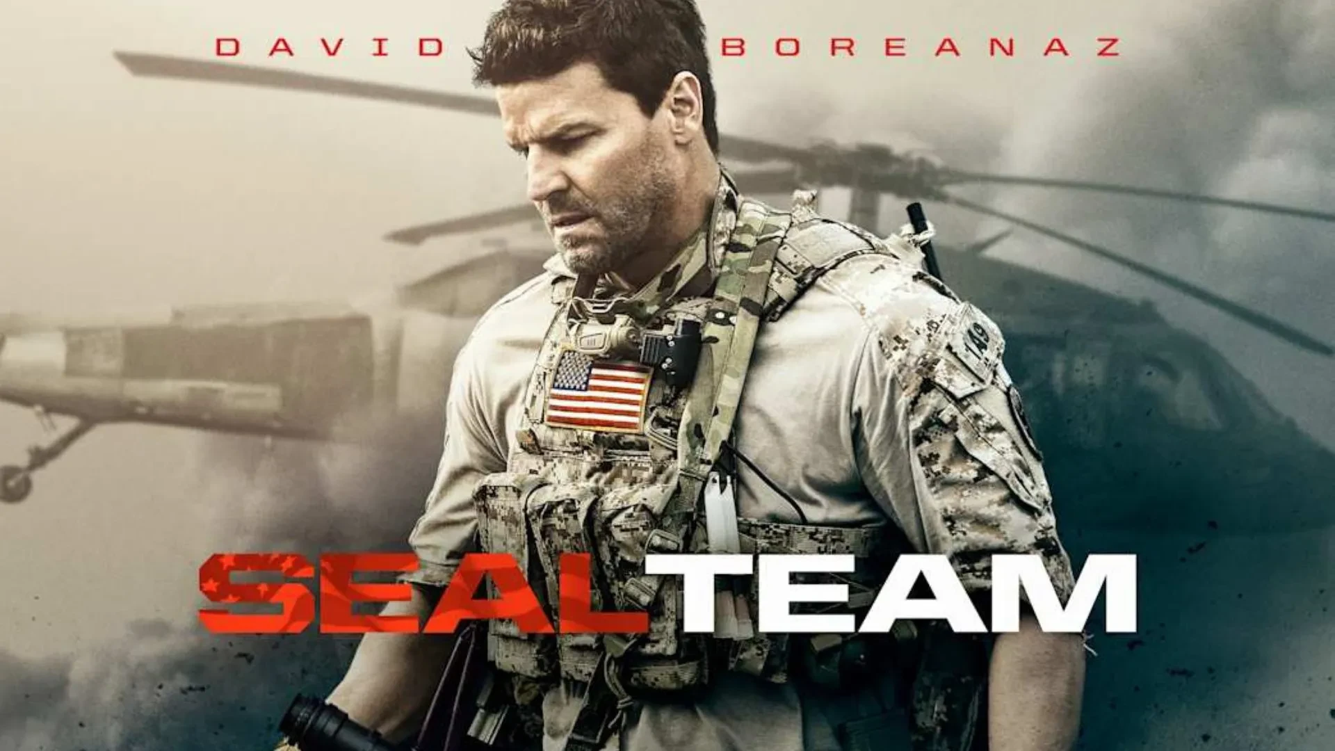 A man in his forties wearing US army uniform looking down, with a helicopter in the background. Writing in front of him that reads SEAL Team