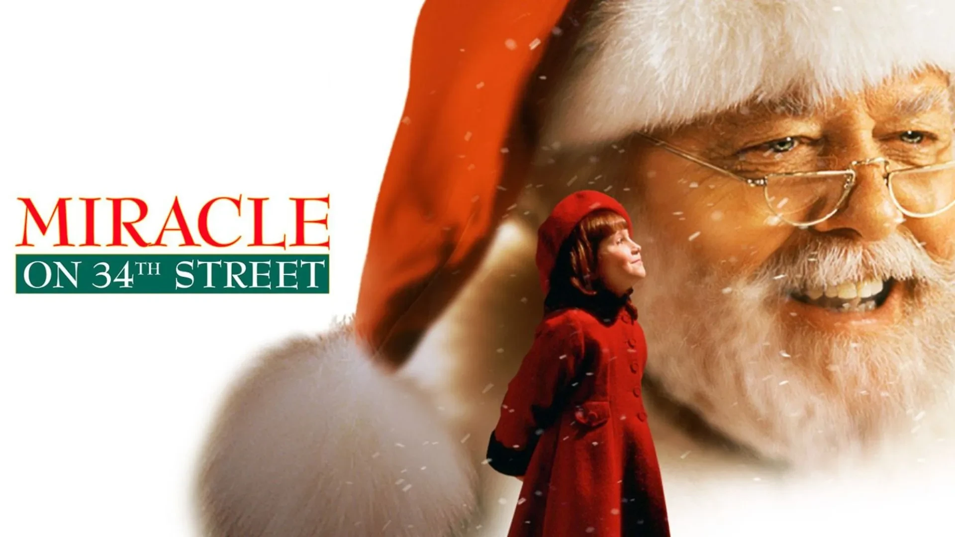 Child in a red coat standing in front of a giant Santa hat with snow falling and “Miracle on 34th Street” text.