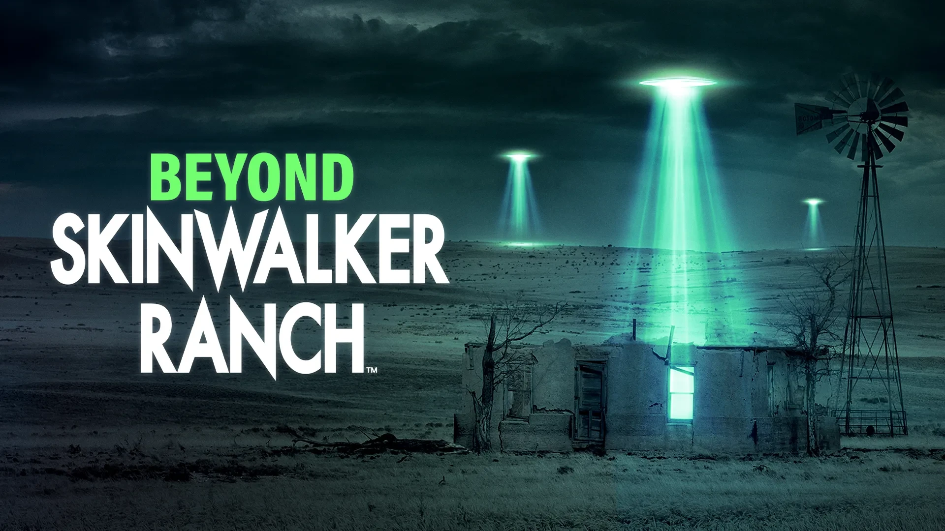 A nighttime rural landscape features several UFOs projecting green beams of light onto open fields. An abandoned structure and windmill stand in the foreground. The text “BEYOND SKINWALKER RANCH” appears on the left.