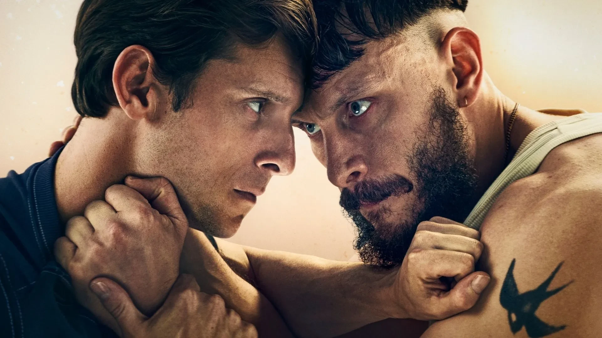 Jamie Bell and Richard Gadd as characters Rueben and Niall in the drama Half Man, staring angrily at each other with their arms on the othersneck