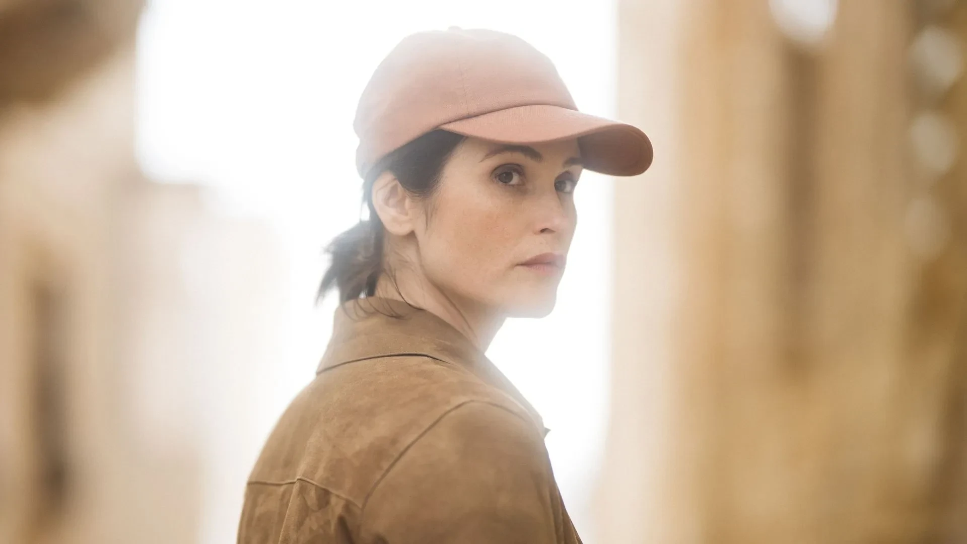 Gemma Arterton as Kate Henderson in ITVs spy drama Secret Service, wearing a pink hat and beige jacket.