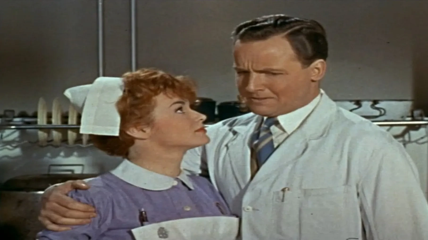 A film still from the 1960 British comedy Doctor in Love, featuring Michael Craig as Dr. Richard Hare and Virginia Maskell as Dr. Barrington