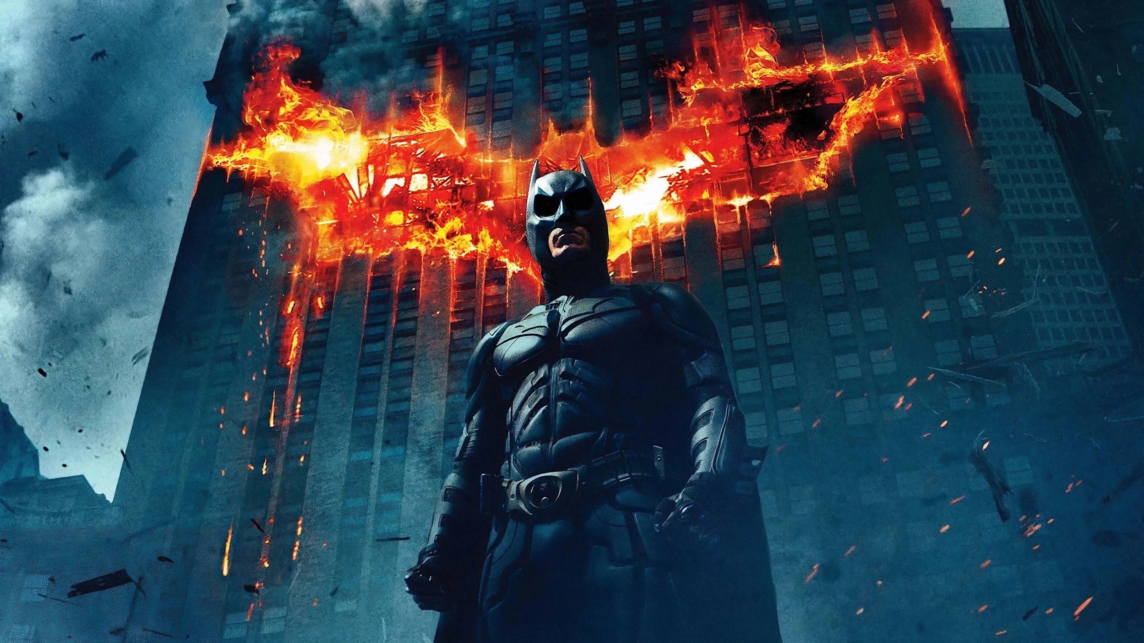 Image promoting The Dark Knight showing Christian Bale as Batman against a flaming wings background