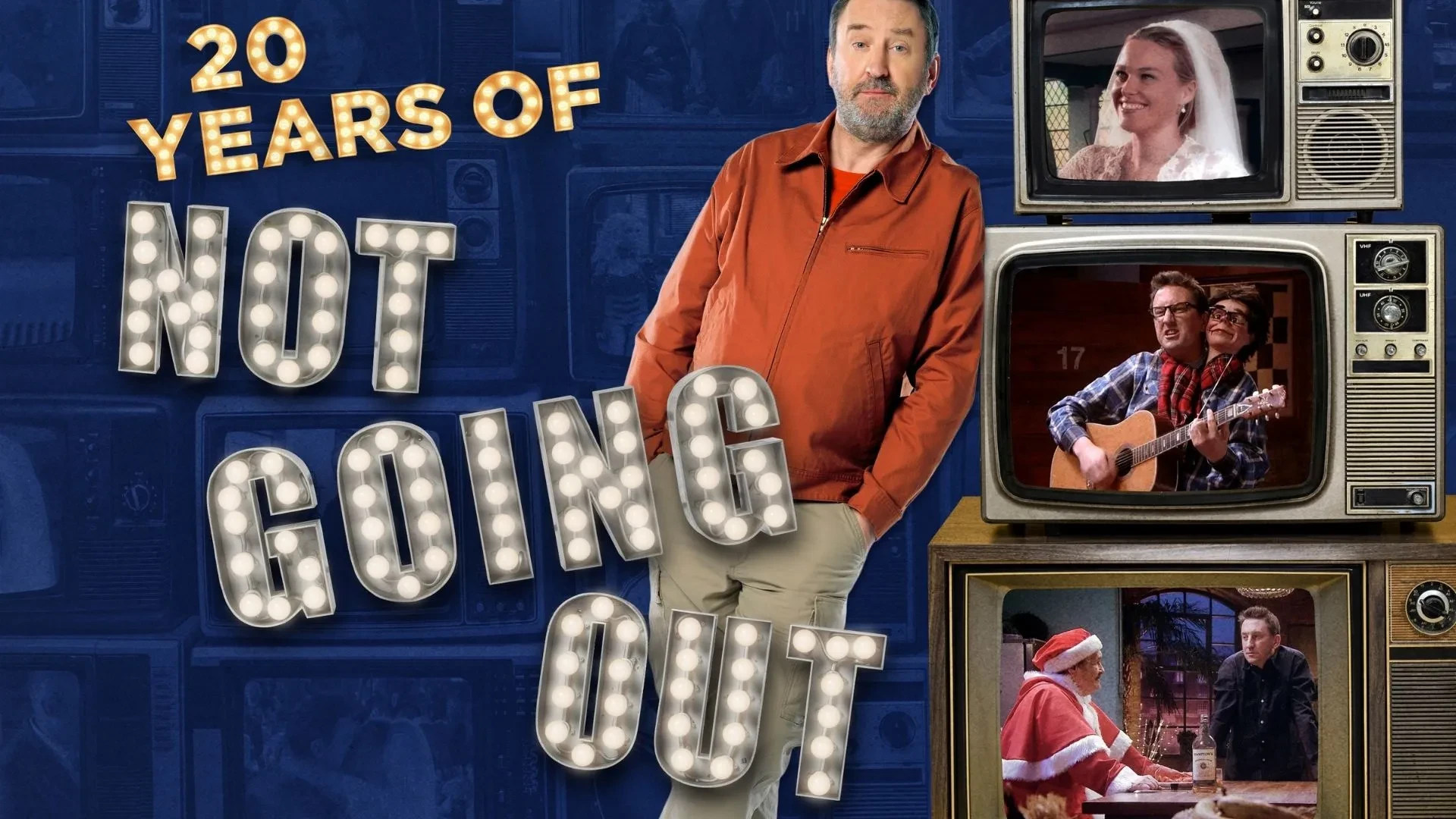 lee Mack wearing an orange jacket leaning against three old school TVs containing old episodes of the TV shows Not Going Out. Writing to the left of Lee that reads "20 years of Not Going Out".