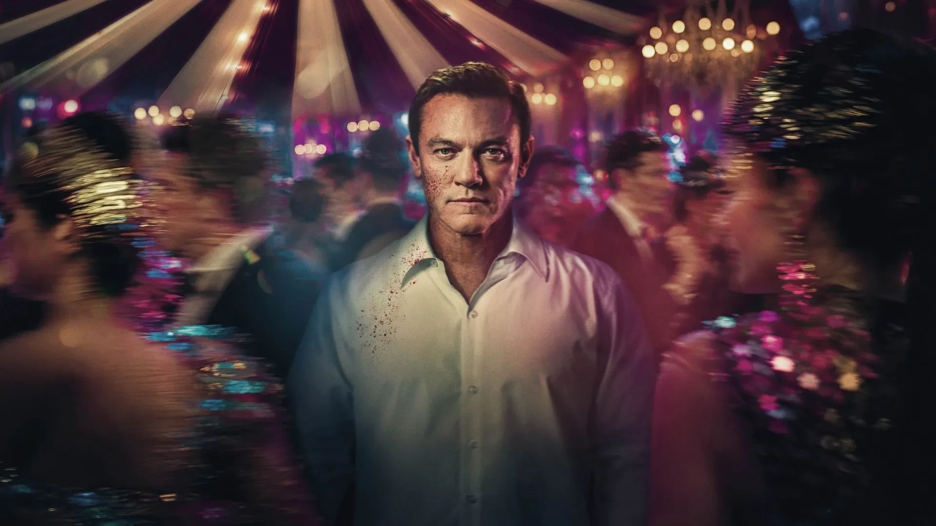 Luke Evans as Martin Gilmour in ITVs new drama The Party, stood in the middle of a party with a circus tent in the background.